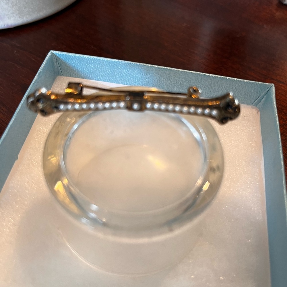 Goldtone and faux Pearl pin.